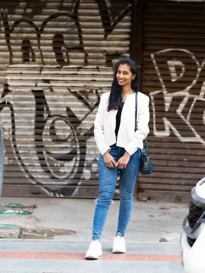 Using the contrast between cars and a graffiti wall to frame the subject. This is a classic Bangalore street photography setup.