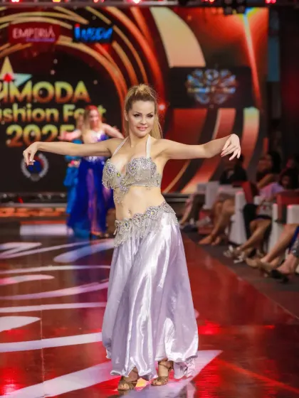Another angle of the dancer in the silver costume, showcasing her elegant posture and the energy of the performance.