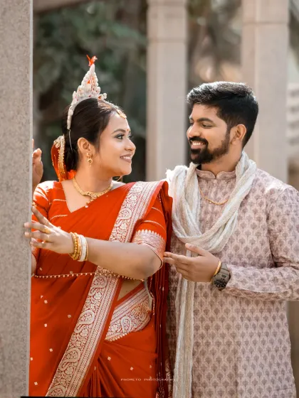 A playful, candid moment between the Bengali bride and groom, their expressions full of love and happiness.