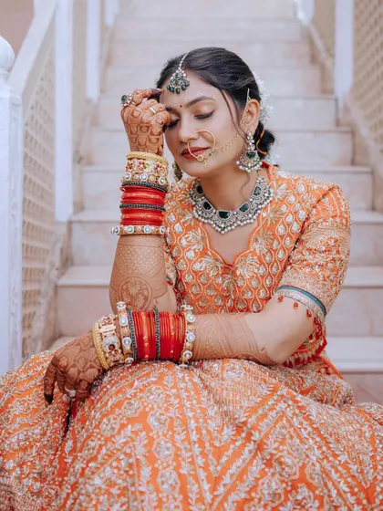 A beautiful candid shot of the bride, highlighting her henna-adorned hands and stunning jewelry.
