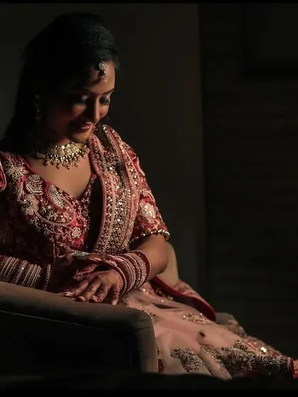 A pensive and elegant portrait of the bride-to-be, seated and captured with artistic, low-key lighting.