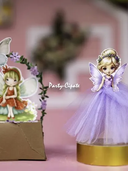 Handcrafted fairy figurines used as table decor. These small touches, like the tulle skirts and detailed wings, add a layer of charm and personality to the overall setup.