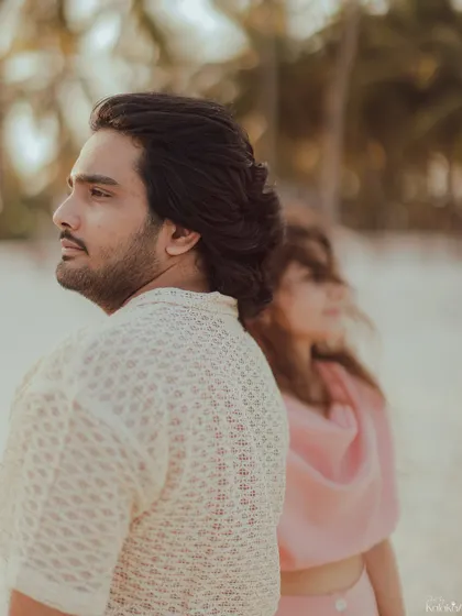 An artistic portrait with the couple standing back-to-back, looking in different directions, creating a sense of individuality and shared space.