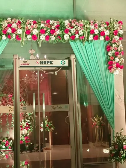 Here is another hotel entrance I decorated, using a combination of fresh flowers and fabric. The mint green drapes paired with red and white floral arrangements create a fresh and elegant look.