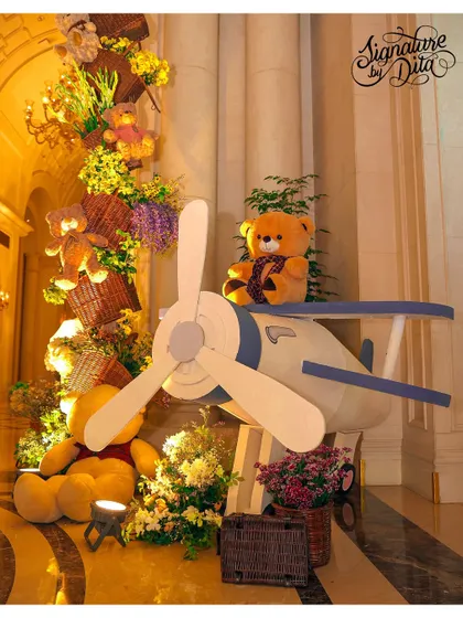 A large vintage airplane prop with a teddy bear pilot, part of the whimsical decor for the London-themed first birthday.