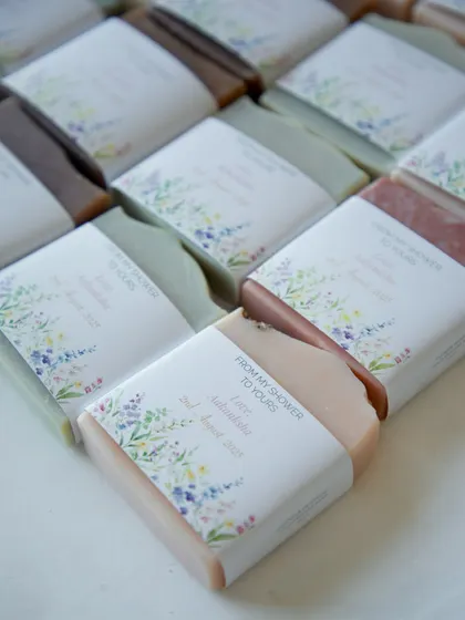 A close-up of the 60 custom soaps I packed for a baby shower. The variety of natural colors in the soaps peeks through the beautifully designed floral labels.