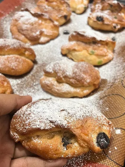Freshly baked Stollen, a traditional German Christmas bread filled with dried fruit and nuts, dusted with powdered sugar.