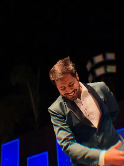 A candid, happy moment captured mid-performance on the Sangeet stage.