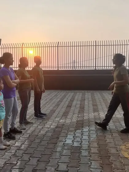 An instructor leads the group in pre-practice exercises against a beautiful sunset. We train the body and the mind.