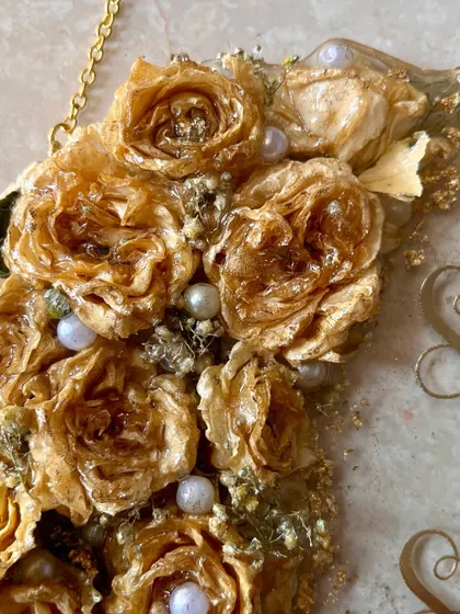 A close-up of the 3D preserved golden roses and pearls on a wall-hanging frame. The detail and craftsmanship in each flower are what make these pieces so special.