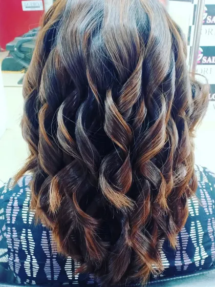 Bouncy curls are the perfect way to show off fresh highlights. The light catches the different tones, creating a stunning, dimensional effect.