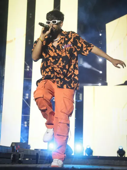 An action shot of KhullarG mid-performance, showcasing his energetic style. I focus on capturing the dynamic movements that define a rap performance.
