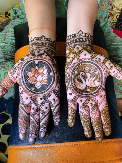 A beautiful design featuring a lotus in a central circle on one hand and two swans on the other. This kind of symbolic and personalized art is perfect for any festive occasion.
