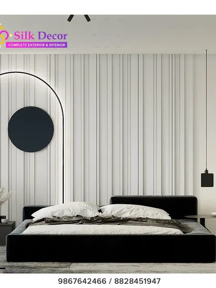 A bold, minimalist bedroom centered around our custom black platform bed. The stark, simple frame provides a strong anchor for the room, contrasting with the textured white wall and demonstrating our versatility in modern design styles.