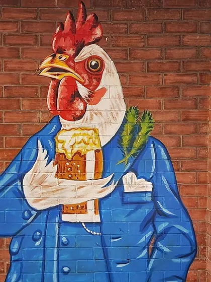 This well-dressed rooster in a suit, holding a mug of beer, is one of our favorite characters from the Plan B mural series.