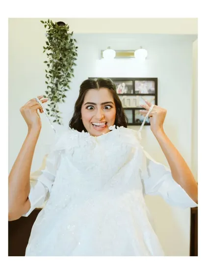 A fun and playful shot of the bride with her wedding dress. This image captures the excitement and personality of the bride before the ceremony.