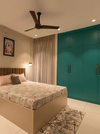 This master bedroom is adorned with soothing turquoise hues and warm lighting. The floor-to-ceiling wardrobe provides ample storage, while the soft furnishings create a cozy and inviting atmosphere.