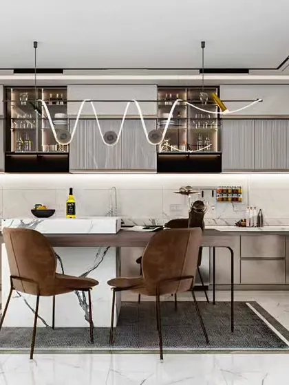 A premium kitchen design featuring a marble-top island and a striking wavy light fixture. The layout includes integrated glass-front cabinets for display and ample counter space for a seamless cooking experience.
