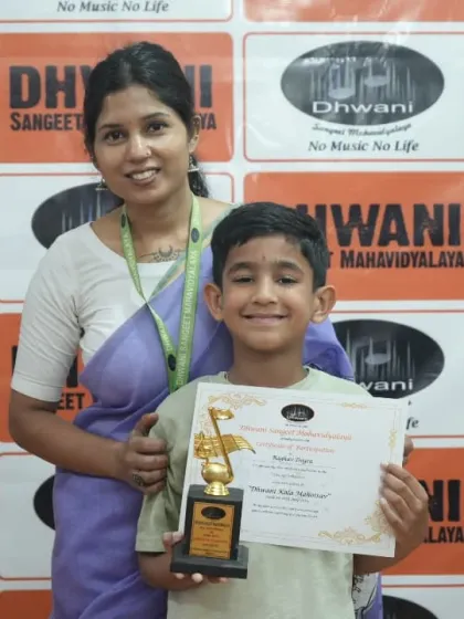 A faculty member and a young student pose with his award.