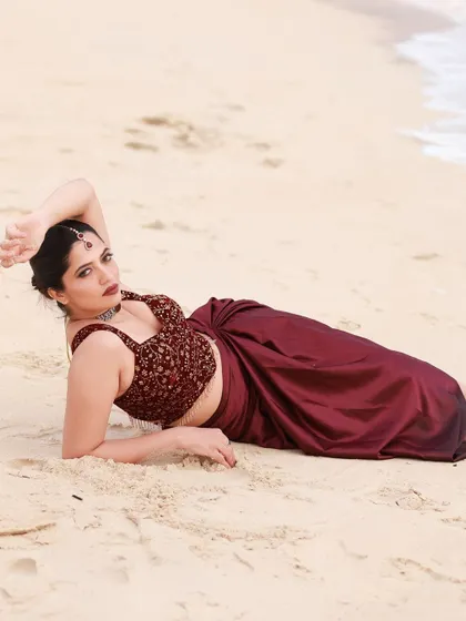 A beachside fashion shoot for a designer's modern-ethnic collection. The models are posed against the sea and coastal rocks to create a windswept, editorial feel that highlights the clothing.