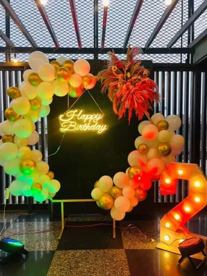 A lovely Boho-themed birthday setup. This design uses a mix of pastel and chrome balloons on a semi-arch, with dried floral arrangements and a '2' marquee number for a trendy and artistic look.