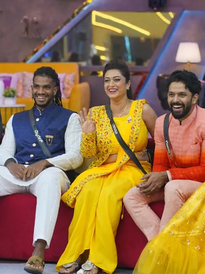 Karthik Mahesh sharing a laugh with fellow contestants. He is wearing a custom-designed ombre orange and peach Indo-Western outfit from my studio.