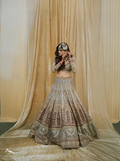 A candid moment of the bride adjusting her earring, showing the makeup from a different angle.