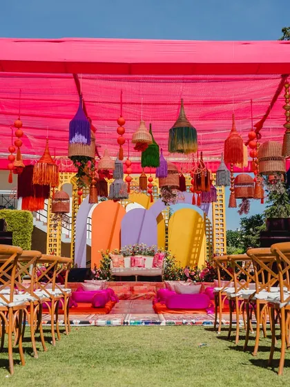 The main seating area for the Souk-themed Haldi, featuring a colorful backdrop and eclectic hanging lanterns.