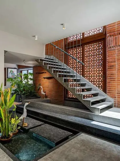 Here, I've integrated a shallow water body with stepping stones right into the home's interior design. The combination of water, stone, and plants next to the exposed brick wall creates a rich, sensory experience.