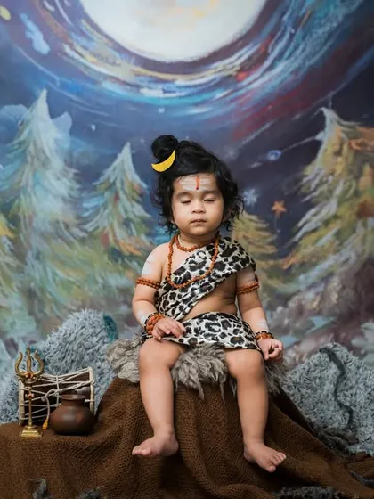 A serene moment captured during our Maha Shivratri themed shoot. This little one, dressed as Shiva, is in a meditative pose, showcasing a different, more peaceful side of these cultural portraits.