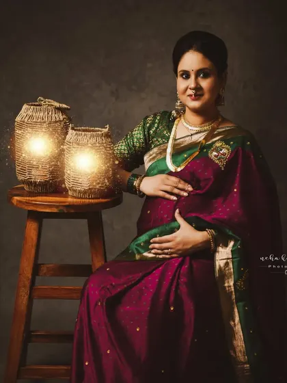 A classic portrait that beautifully captures the essence of a traditional Indian maternity celebration.