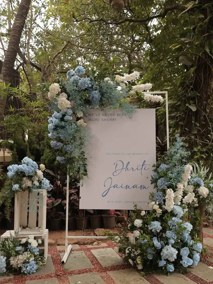 A chic welcome sign for a pastel blue brunch. The sign is framed by a beautiful arrangement of blue and white hydrangeas, setting a sophisticated and dreamy tone for the event.