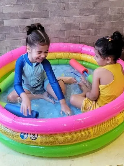 The smiles say it all! Two girls share a laugh in one of our small inflatable pools during a water play session. It’s a great space for imaginative games and cooling off.