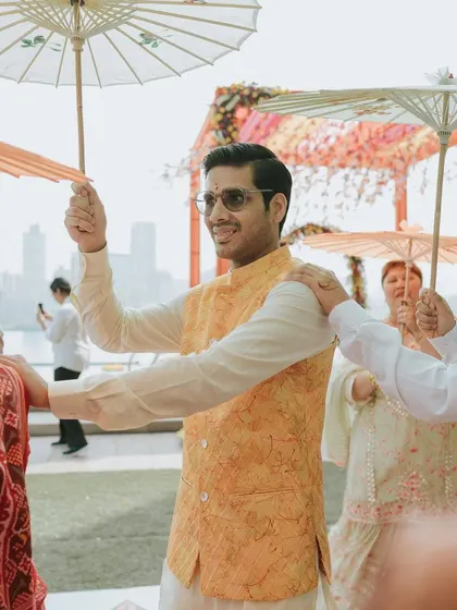 Guests use traditional paper umbrellas to beat the heat at a sundowner Haldi, a thoughtful and stylish detail we provided.