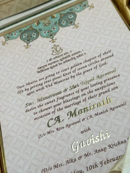 The invitation insert from the sea-green hamper, featuring elegant gold foil script and a Ganesha blessing for the auspicious occasion.
