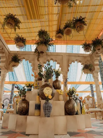 The central bar area, adorned with an array of textured vases and hanging floral installations. The design under the canopy creates a focal point of beauty and craftsmanship.