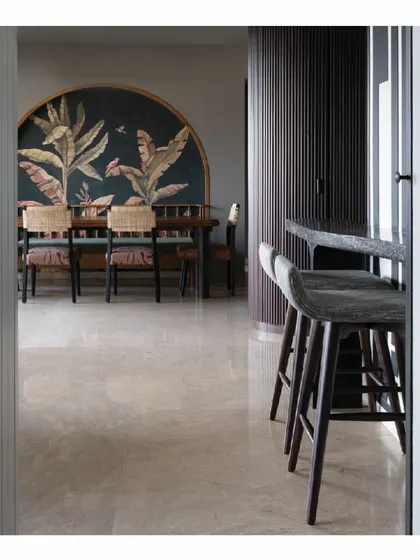 A view from the bar stools into the dining area of the 'Powai House'. We designed the layout to be conversational, allowing spaces to flow into one another while maintaining their distinct functions. The custom furniture pieces tie the areas together.