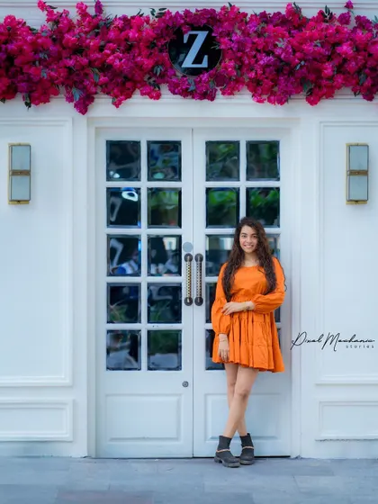 This full-length shot showcases how an entire scene can come together. The architecture, the flowers, and the outfit all work in harmony for a complete fashion-style portrait.