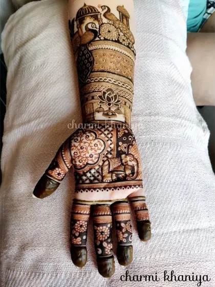 A single hand from a bridal mehendi set, showcasing a beautiful peacock and elephant design. The details are what make it so special.
