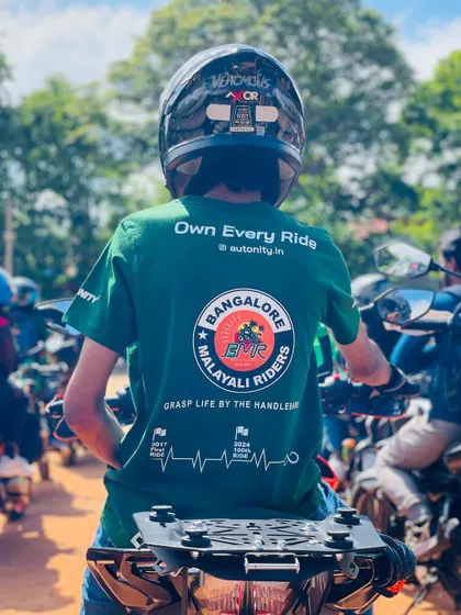 "Own Every Ride." A rider wearing our custom BMR T-shirt, surrounded by fellow bikers at a WMD event. This image embodies our spirit and our motto to "Grasp Life By The Handlebars."