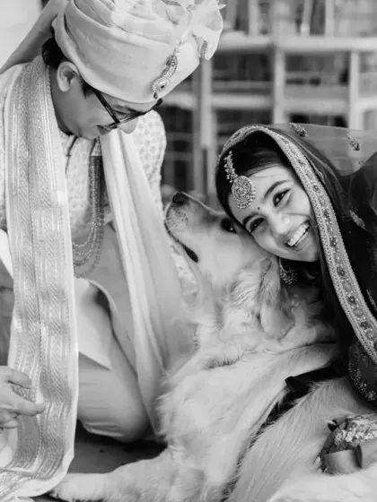 A heartwarming black and white shot of the bride and groom with their beloved dog, a special member of the family.