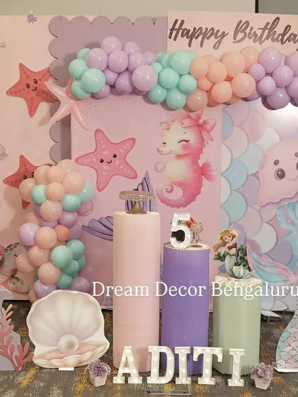 A sweet mermaid theme for a fifth birthday. The pastel color palette and cute sea creature cutouts like seahorses and jellyfish create a dreamy underwater world.