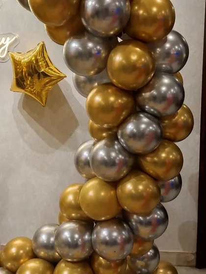 Detail of the chrome gold and silver balloon arch, showing the clean and modern aesthetic.