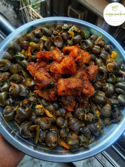A unique dish of river snails ('tharoi') served with spicy pork stir-fry on top.
