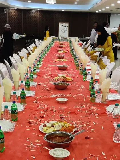 Our team setting up for a 'dawat'. You can see our staff arranging the final touches on the long Dastarkhwan table, ensuring everything is perfect before the guests arrive.