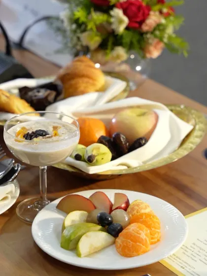 A healthy and elegant breakfast spread, featuring fresh fruit, a smoothie, and pastries. We provide complete catering solutions, from breakfast meetings to evening galas.