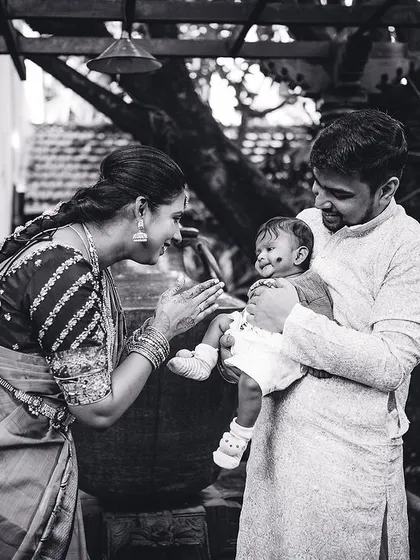 A tender black and white photo of new parents admiring their baby. These quiet, intimate family moments are just as important as the main ceremony.