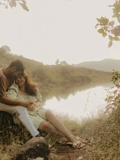 A serene and intimate portrait of a couple nestled by a calm lake. The vintage, rustic tones of this photo enhance the feeling of warmth and tranquility in this nature-filled pre-wedding shoot.