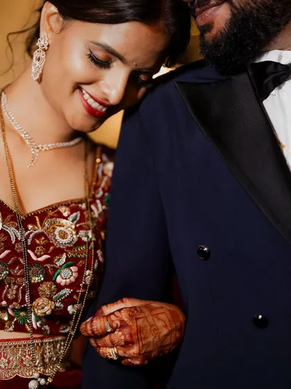 A close-up shot filled with warmth and happiness. The bride's joyful smile as she rests on the groom's shoulder tells a beautiful story of love and comfort.