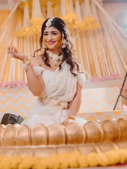 Capturing the pure joy of the Haldi ceremony. The bride is showered with flowers and turmeric, and my decor with its bright yellow drapes and floral accents creates a perfectly festive atmosphere.